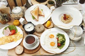 Four breakfast on a wooden table surrounded by various elemeetov on a wooden table
