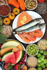Healthy diet food concept with a selection of fresh seafood, fruit, vegetables, seeds and grains with super foods high in omega 3, vitamins, minerals, anthocyanins, antioxidants and fibre. Top view.
