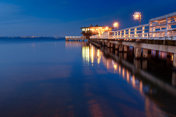 Illuminated pier in Puck at night. Baltic Sea, Poland. - obrazy, fototapety, plakaty