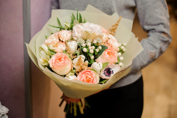 female holds a bouquet with white poppies, pink roses and pink astilba
