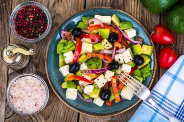 Vegetable salad with feta on wooden background