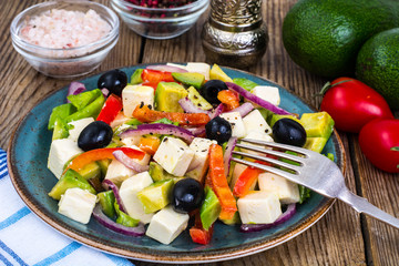 Vegetable salad with feta on wooden background
