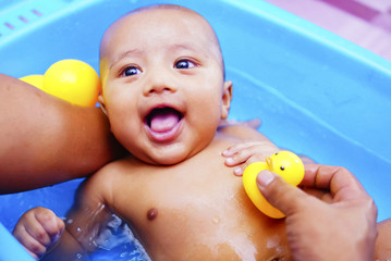 Baby Boy Having Bath In Bathtub With Father Help