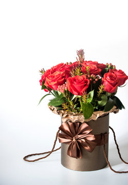 Vertical photo of the flowers bouquet in the brown vase isolated on light background