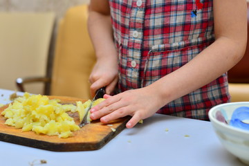 Smiling girl squeezing lemon juice into blender with water and sliced fruit while preparing smoothie