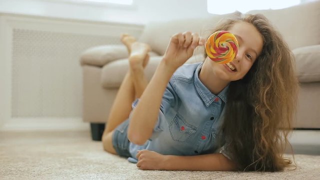 Beautiful fair-haired teen girl with Candy. Playful Cute Girl with Big Sweet Lollipop.