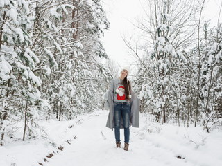 Cute and happy girl in a beautiful snowy forest