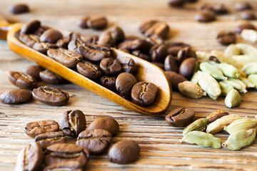 Coffee beans with cardamom on rustic table