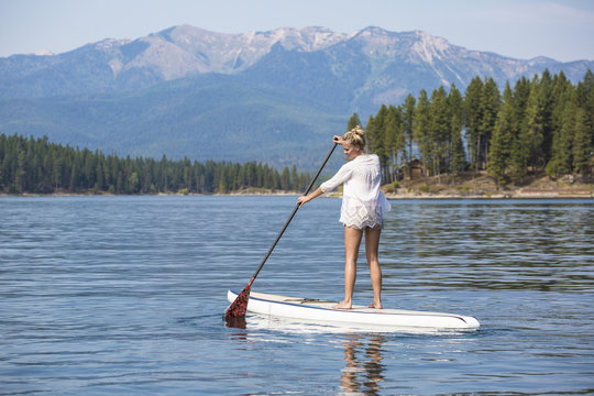 Beautiful Woman Paddle Boarding On Scenic Mountain Lake