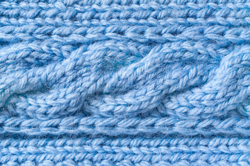 Fototapeta na wymiar Blue woolen fabric with a fragment of a pigtail pattern (background, texture, abstract)