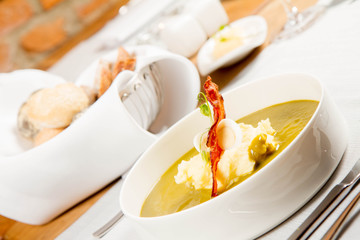 Cream of sorrel and green vegetables soup with quail egg, sour cream, mashed potatoes and crispy...