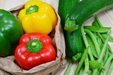 colorful paprika, peas and zucchini on wooden table