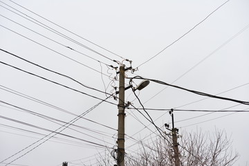 Chaos of cables and wires on electric pole, Messy wires attached to electrics pole in Bangkok, Thailand on blue sky background.