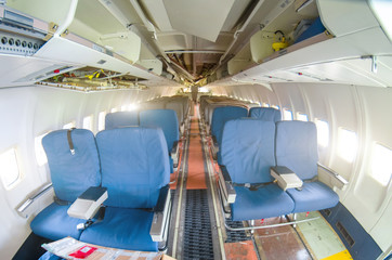Fototapeta premium Destroyed passenger cabin aircraft. Torn off passenger seats destroyed interior cabin airplane with seats, for repairs.