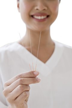 Woman holding acupuncture needles