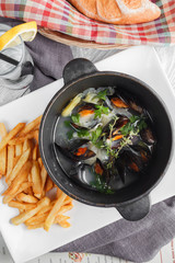 Mussels in a pot served with fried potato. Top view. Restaurant menu conception