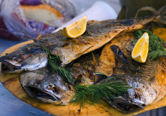 Fried fish in sour, sweet sauce, parsley. On a wooden tray