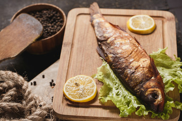 Fried fish on plate with vegetables