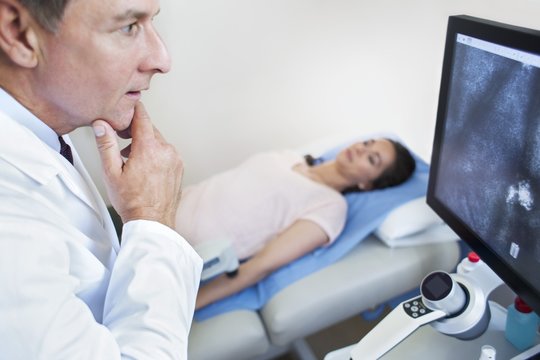 Doctor looking at screen with hand on chin