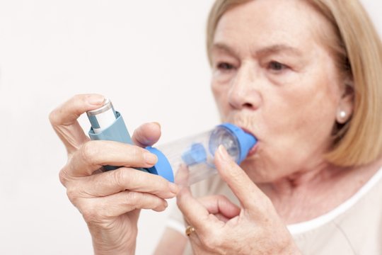 Senior woman using an inhaler