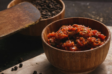 Thai spicy mixed salad on dark in wooden bowl
