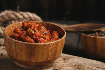 Thai spicy mixed salad on dark in wooden bowl