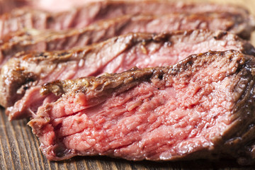 Scheiben eines Steaks auf Holz mit Rosmarin