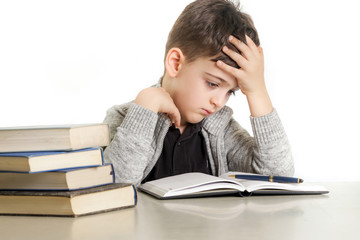 Studio portrait of young boy struggling with his homework - learning difficulties concept