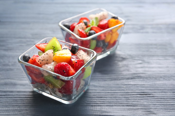 Dessert bowls with delicious fruit salad on wooden table