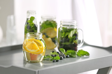 Fototapeta na wymiar Glassware of infused water with fruits and berries on table