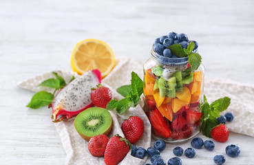 Jar with fruits and berries on table