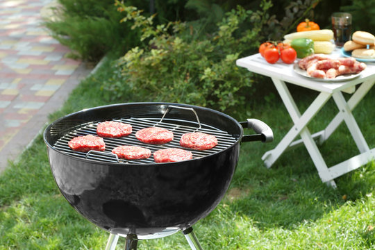 Barbecue grill with tasty patties on backyard