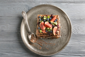 Plate with tasty sweet toasts on wooden background