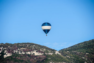 Fototapeta na wymiar A hot air balloon, in flight to the mountains