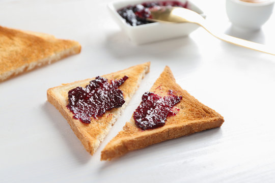 Tasty toast with jam on white table