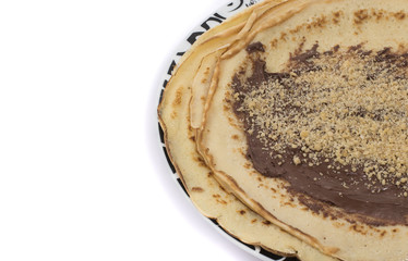 Pancakes with cream and walnuts on a white background