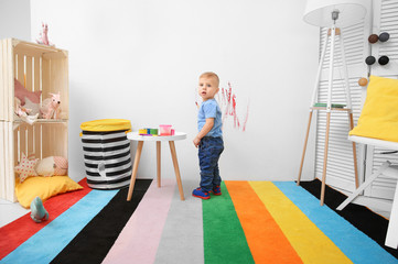 Little boy painting on wall at home