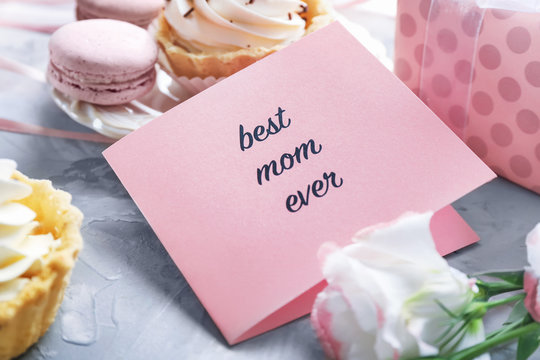 Greeting card with words "Best mom ever" on table, closeup