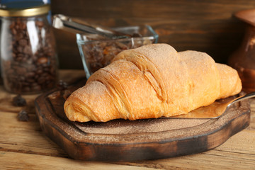 Board with fresh yummy croissant on table