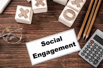 Sheet of paper with text SOCIAL ENGAGEMENT on office table