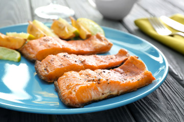 Plate with delicious fried rainbow trout on table, closeup