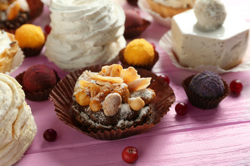 Assortment of tasty sweets on wooden background