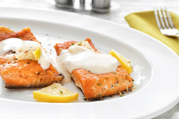 Tasty rainbow trout fillets with sauce on plate, closeup