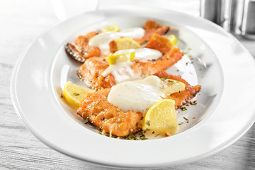 Tasty rainbow trout fillets with sauce on plate