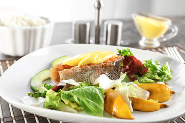 Tasty rainbow trout steak with garnish and sauce on plate, closeup