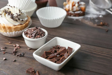 Composition with chocolate toppings for pastries on wooden background