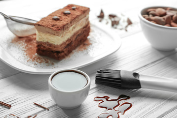 Chocolate syrup and tasty cake on wooden table