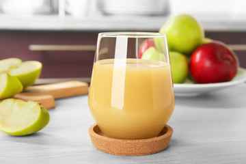 Glass of delicious apple juice on kitchen table © Africa Studio