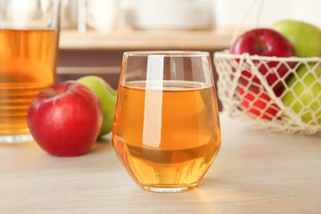 Glass of delicious apple juice on kitchen table