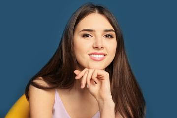 Naklejka premium Attractive young woman smiling on color background